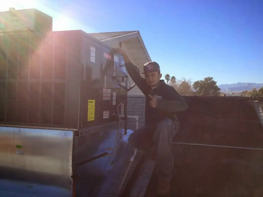 HVAC technician performing AC Tune-Up on a rooftop unit in Gardena